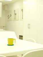 Detail of white dining table in kitchen diner with green mug on table