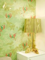 Detail of gold lamp and green patterned wallpaper