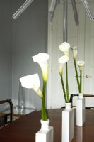 Lilies in vases on dining tables