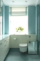 Modern bathroom with fitted storage and blue mosaic tiled walls and floor