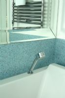 Modern bath with blue mosaic tiles and handheld shower