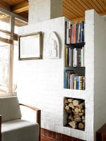 Living room with storage for books and firewood within brickwork 