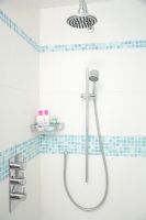 Modern shower with white tiles and mosaic strips 