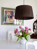Detail dining table with tulips and large low ceiling light