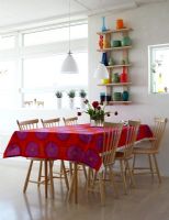Modern dining room with brightly coloured tablecloth 