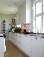 Kitchen with white units and parquet flooring