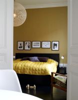 View to modern bedroom with gold bedspread