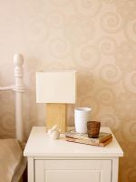 Bedside cabinet and wallpapered wall