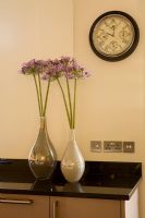 Kitchen worktop with flowers in vases 