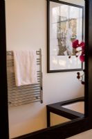 Bathroom mirror showing towel radiator in reflection 