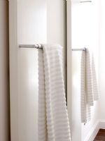Towels hanging on radiators in modern white bathroom
