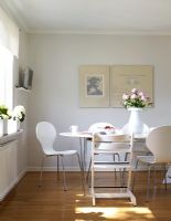 Contemporary white dining room with Piet Hein table and butterfly chairs by Arne Jacobsen