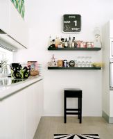 Modern kitchen with black shelves and stool