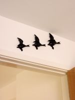 Ceramic ducks flying on wall display