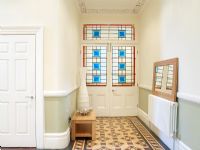 Hallway with patterned tiled floor and stained glass doors