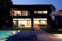 Modern house exterior at night with pool 