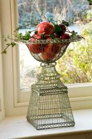Ornate wire containers with apples, ivy and pomegranites
