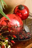 Decorative red christmas tree baubles in a wire rack
