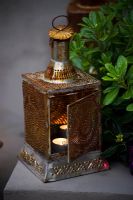 Moroccan lantern with lit candle in garden