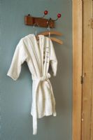 View of bathrobe hanging from hook on wall
