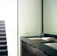 View of bathroom sink and staircase in background