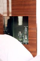Glass and jug in built-in shelf beside bed