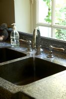 Kitchen sink with water flowing from tap