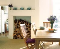 Modern dining room with logs in fireplace