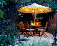 Table and chairs in garden with illuminated umbrella