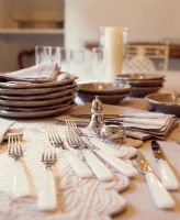 Cutlery, plates and placemats on dining table