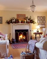 Living room with decorated mantelpiece and burning fire at Christmas