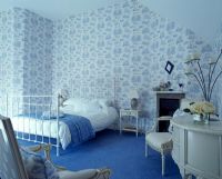 Bedroom with patterned wallpaper and blue carpet