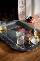Tray with drinks glasses and decanter on table beside fireplace