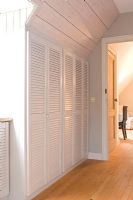 Hallway closet with natural wood panelling