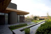 Modern house exterior with pond 