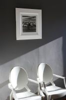 Two chairs against a grey wall
