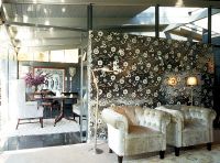 Two armchairs against a floral pattern silver wall