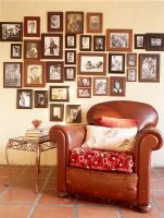 Leather Armchair in front of photo collection on wall