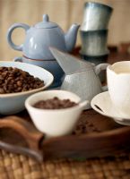 Coffee beans in cup with tea pot