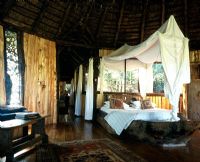 African safari bedroom with a canopy bed