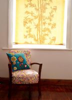 Floral patterned armchair in front of window with yellow blind