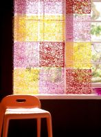 Chair next to a colorful window decoration