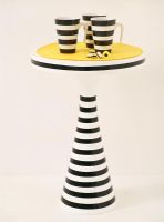 View of black and white striped mugs on matching table