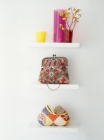 Handbag and flower vase on shelf