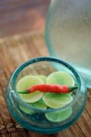 Glass bowl with sliced lime and a red chili