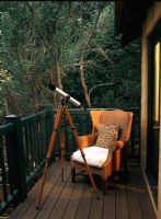 Small wooden balcony with an armchair and telescope