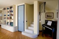 Living room with stairs and piano in alcove