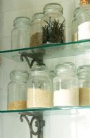 Close-up of jars of spices on glass shelves