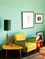 Armchair beside side table with floor lamp