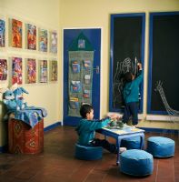 Children drawing and playing in a play room